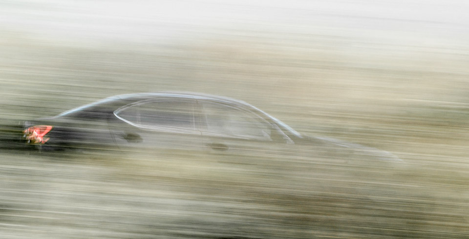 Panning shot of car passing behind hedgrow, Seven Sisters, East Sussex